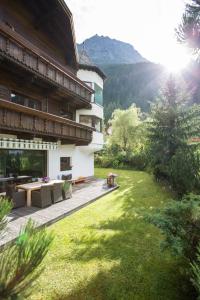 a house with a patio and a grass yard at Hotel Hafele in Kaunertal