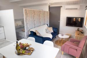 a living room with a blue couch and a tv at Le chalet aux Etoiles Spa & Sauna in Pézenas