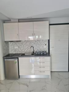 a kitchen with white cabinets and a sink at Apartments Nera Paralia-Apartment with sea view in Paralia Katerinis