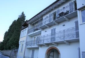 a white building with balconies on the side of it at appartamenti i fiori del lago in Laveno-Mombello