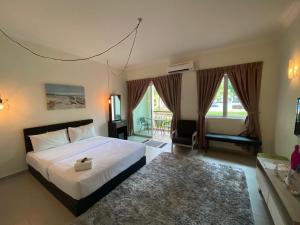 a bedroom with a large bed and a balcony at Tiara Desaru Resort in Desaru +89 photos