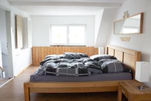 Schlafzimmer mit einem Bett mit einem Kopfteil aus Holz und Kissen in der Unterkunft Ferienhaus Deko-Scheune in Naila