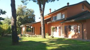 an orange house with trees in the yard at Villa Bruna in Cesenatico