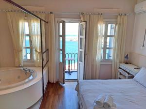 a bedroom with a tub and a bed and a bathroom at Hotel Amphora in Chania Town