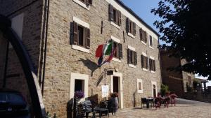 a building with a flag on the side of it at Locanda del Borgo in Langa in Prunetto