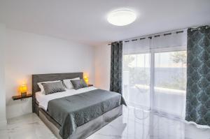 a bedroom with a bed and a large window at Apartman Izzy in Senj