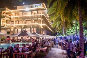 a group of people sitting at tables in front of a building at Paradise Beach Club in Mirissa