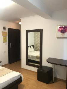 a bedroom with a bed and a desk and a mirror at Pensiunea Max in Cluj-Napoca