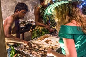 a man standing next to a woman preparing food at Paradise Beach Club in Mirissa