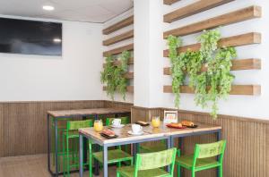 comedor con mesa y sillas verdes en Pierre & Vacances Benidorm Levante, en Benidorm