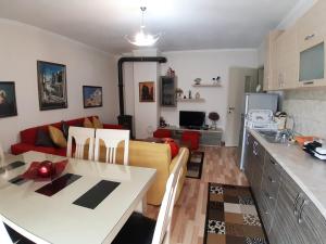 a kitchen and living room with a couch and a table at PERLES Apartament KORCE in Korçë
