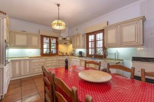 a kitchen with a table with a red table cloth at Finca La Cabra in Ronda