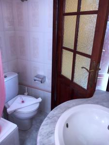 Un baño con inodoro, lavabo y puerta. en Casa Gusber I, en El Paso 15 fotos más