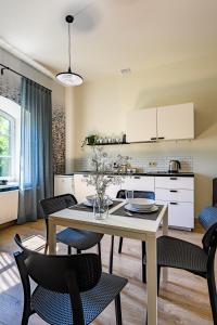 a kitchen and dining room with a table and chairs at Modern studio - 10min walk to the sea in Liepāja