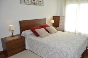um quarto com uma cama grande e almofadas vermelhas em Apartamento con vistas en Cambados em Cambados