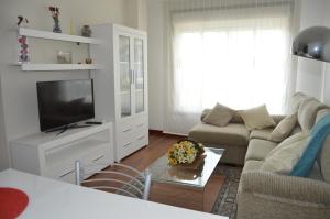 a living room with a couch and a tv at Apartamento con vistas en Cambados in Cambados