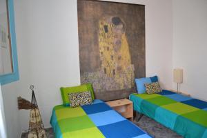 TabayescoにあるCasitas Tabayescoのベッド2台が備わる客室で、壁には絵画が飾られています。