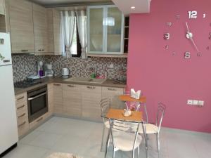 a kitchen with a table and a pink wall at Ήσυχο σπίτι στη Ναύπακτο in Nafpaktos