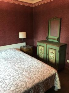 a bedroom with a bed and a dresser and a mirror at T klein Kasteeltje Wetteren in Wetteren