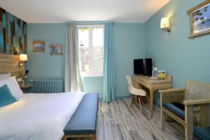 a hotel room with a bed and a desk with a computer at Hôtel de France in Ornans