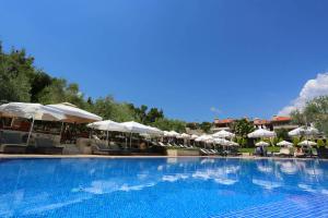 una gran piscina con sombrillas y sillas en Kassandra Village Resort en Pefkohori