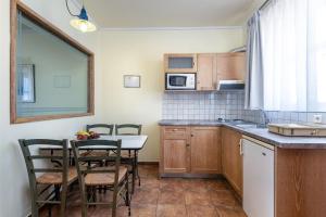 a kitchen with a table and chairs and a kitchen with a counter at Aegean Houses in Kos