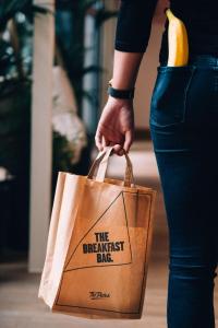 una persona sosteniendo una bolsa de compras con un plátano en The Dutch Maastricht, en Maastricht