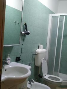 ein Badezimmer mit einem WC, einem Waschbecken und einem Spiegel in der Unterkunft Casa Degli Ulivi in Tivoli