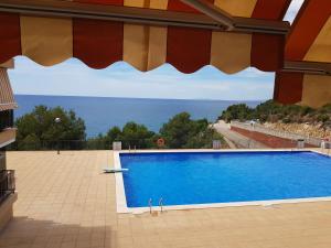 a swimming pool with a view of the ocean at Apartamento con vistas al mar in Salou