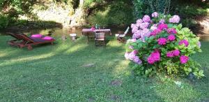 einen Garten mit einem Tisch, Stühlen und Blumen in der Unterkunft Mobile home Camp vikendica Slapnica u Parku prirode Žumberak i Samoborsko gorje in Krašić