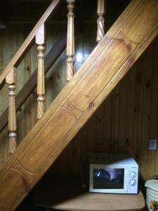 a microwave sitting on a shelf under a staircase at садиба Подвір'ячко in Szack