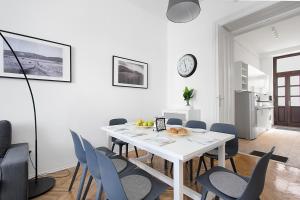 a white dining room with a white table and chairs at BpR COSMOS Design Suite with A/C in Budapest