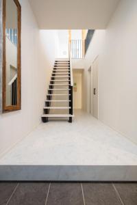 a staircase in a room with white walls and white floors at Hakuba MAHOROBA in Hakuba