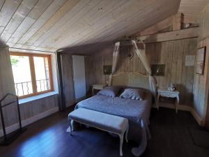 a bedroom with a bed and a table and a window at Le Moulin de la Fortie, maison d'hôtes in Viscomtat
