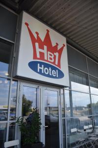 um sinal para um hotel em frente a um edifício em HB1 Budget Hotel - contactless check in em Wiener Neudorf