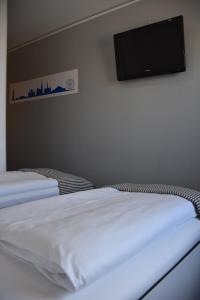 um quarto com 2 camas e uma televisão de ecrã plano na parede em HB1 Budget Hotel - contactless check in em Wiener Neudorf