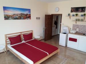 a bedroom with a large red bed and a kitchen at SUNNY SEA PALACE 502 Studio Sunny Beach in Sunny Beach
