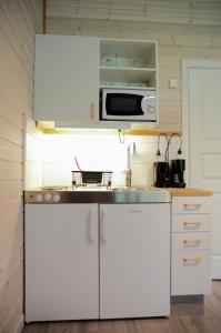 a kitchen with white cabinets and a microwave at Alingsås Golfklubb in Alingsås