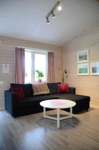 a living room with a black couch and a table at Alingsås Golfklubb in Alingsås