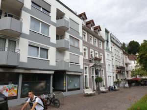 Ein Mann, der vor einem Gebäude Fahrrad fährt in der Unterkunft Sophienstrasse Appartement in Baden-Baden