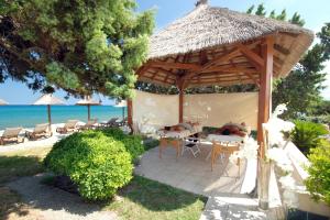 einen Pavillon mit einem Tisch und Stühlen am Strand in der Unterkunft Camping Naturiste Riva Bella 4* in Linguizzetta