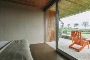 a room with a chair and a table on a porch at Santa Barbara Eco-Beach Resort in Ribeira Grande