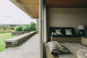 a porch with a couch on a patio at Santa Barbara Eco-Beach Resort in Ribeira Grande