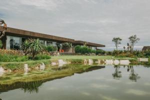 a house with a pond in front of it at Santa Barbara Eco-Beach Resort in Ribeira Grande
