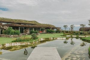 a house with a pond in front of it at Santa Barbara Eco-Beach Resort in Ribeira Grande