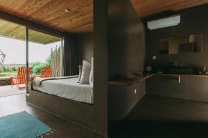 a bedroom with a bed and a view of a patio at Santa Barbara Eco-Beach Resort in Ribeira Grande