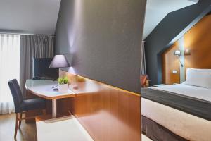 a hotel room with a bed and a mirror at Silken Juan de Austria in Valladolid