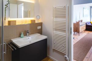 a bathroom with a sink and a mirror at Penthouse am Meer Barth in Barth