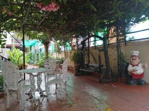 patio ze stołem, krzesłami i posągiem w obiekcie Wannara Hotel Hua Hin w mieście Hua Hin