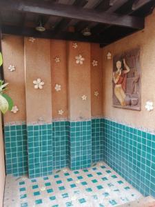 baño con azulejos azules y una pintura en la pared en Wannara Hotel Hua Hin, en Hua Hin
